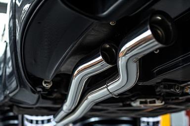 एक कार के नीचे चमकदार स्टेनलेस-स्टील एग्जॉस्ट